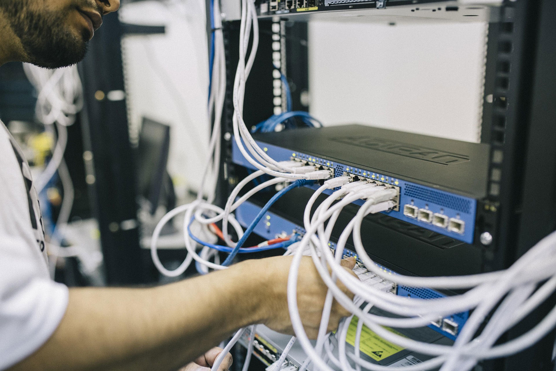 Infotrack engineer verzorgt bekabeling in een serverrack